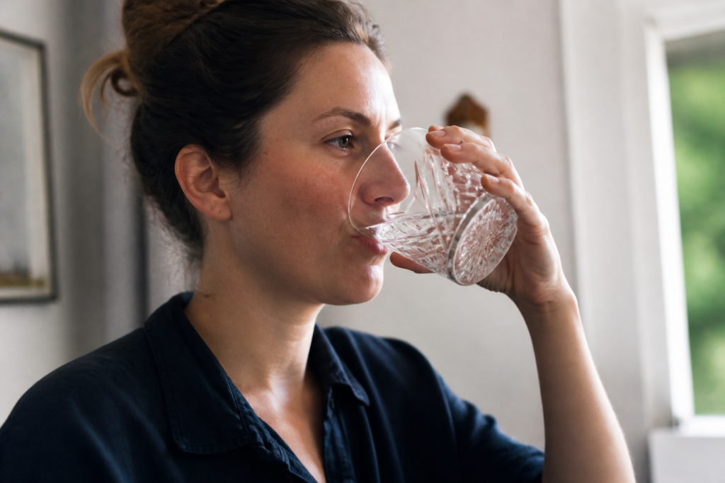 Femme buvant eau dans verre cristal clair