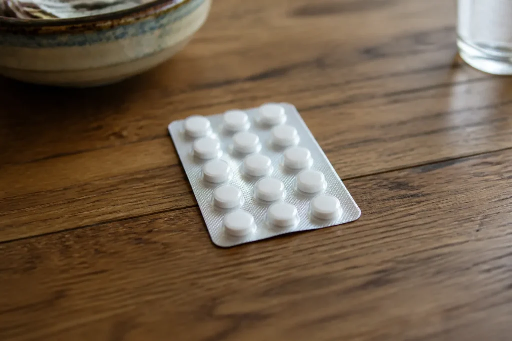 Plaquette de comprimes blancs sur une table en bois
